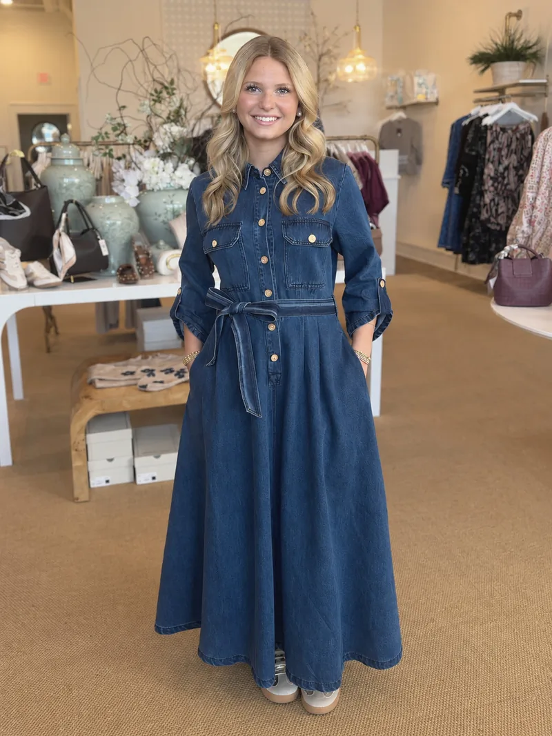 A smiling woman in a denim dress in the shop
