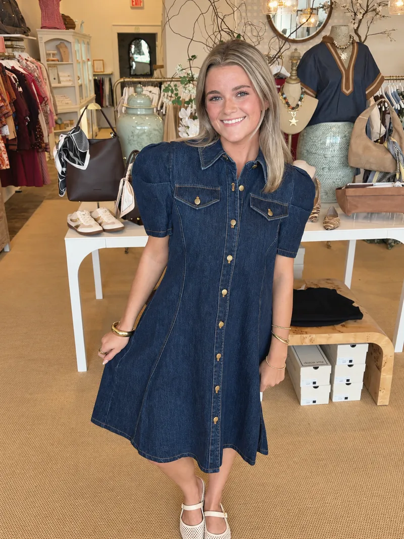 A smiling woman in a denim dress on the shop floor
